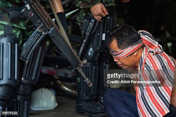 Red-shirt protester is detained by Thai security forces inside their encampment on May 19, 2010 in Bangkok, Thailand. At least 5 people are reported...