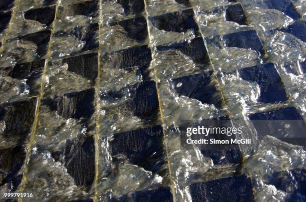 water runs across tiles in a waterfall fountain - australian capital territory 個照片及圖片檔