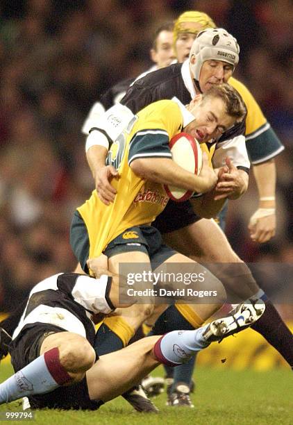 Chris Latham of Australia is stopped by Braam van Straaten and Stephane Glas of the Barbarians during the Scottish Amicable Challenge match between...