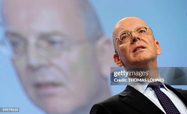 Martin Blessing, chairman of Germany's second biggest bank Commerzbank, is displayed on a giant screen as he speaks to the shareholders during the...