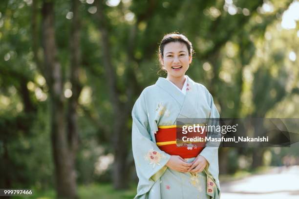 portrait of an asian woman wearing a kimono at the park - masafumi nakanishi imagens e fotografias de stock