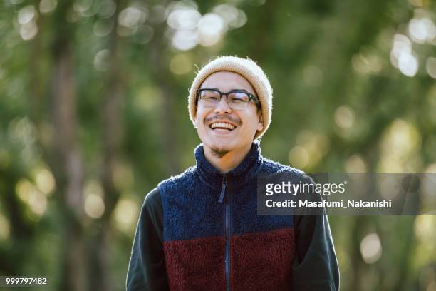 retrato de un hombre asiático que poner las gafas en el parque - masafumi nakanishi fotografías e imágenes de stock