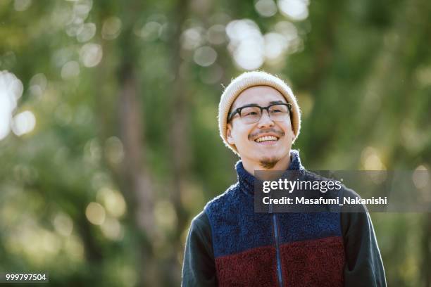 retrato de un hombre asiático que poner las gafas en el parque - masafumi nakanishi fotografías e imágenes de stock