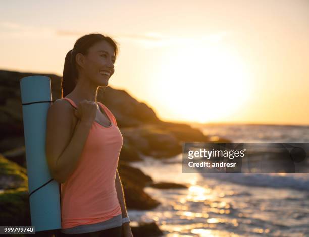 beautiful woman doing yoga outdoors and enjoying the sunrise at the beach - andresr stock pictures, royalty-free photos & images