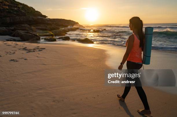 hermosa mujer caminando en la playa disfrutando de la salida del sol - andresr fotografías e imágenes de stock