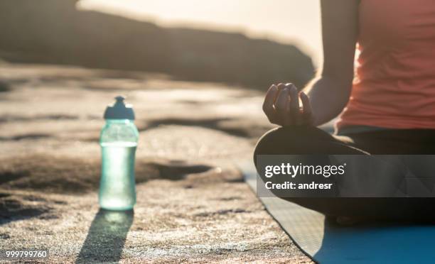 close-up on a peaceful woman meditating outdoors by the sea - andresr stock pictures, royalty-free photos & images