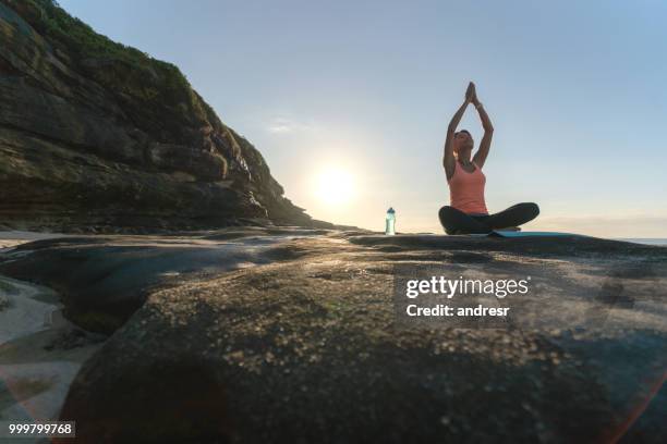 mujer tranquila meditación al aire libre junto al mar - andresr fotografías e imágenes de stock