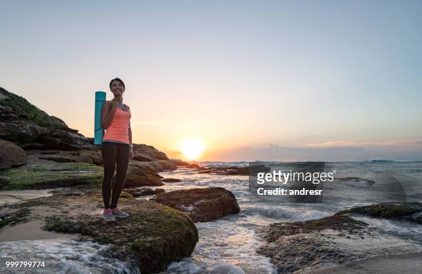 thoughtful woman doing yoga outdoors at the beach - andresr stock pictures, royalty-free photos & images