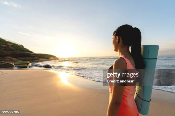 peaceful woman doing yoga outdoors and enjoying the sunrise at the beach - andresr stock pictures, royalty-free photos & images