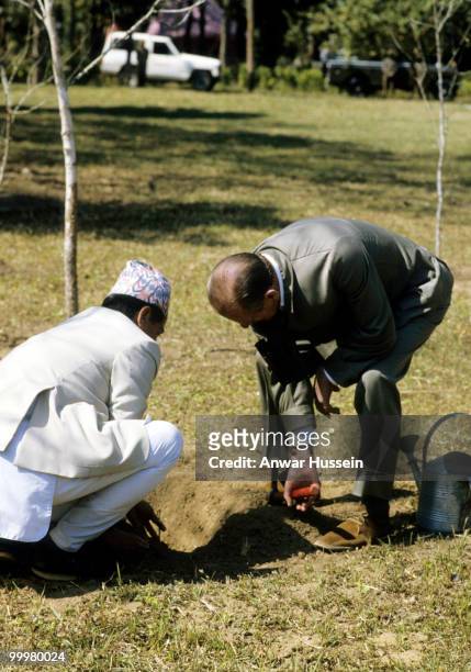 Prince Philip, Duke of Edinburgh plants a tree during a state visit to Nepal on February 18,1986 in Kathmandu, Nepal.