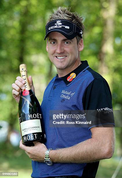 Ian Poulter of England poses with a bottle of champagne received for winning the European Tour Race to Dubai Golfer of the Month award for February...