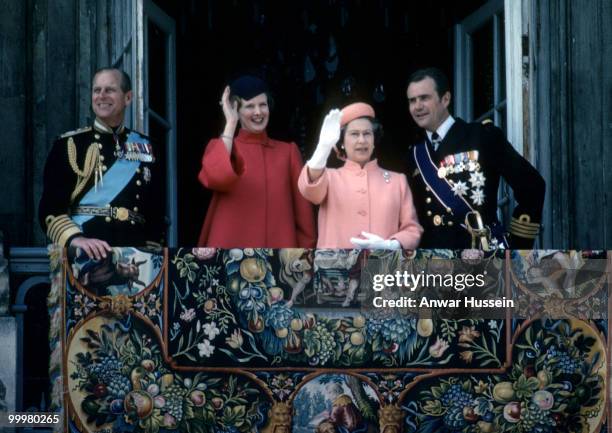 Queen Elizabeth ll and Prince Philip, Duke of Edinburgh with Queen Margarthe and Prince Henrik of Denmark wave from the balcony during a visit to...