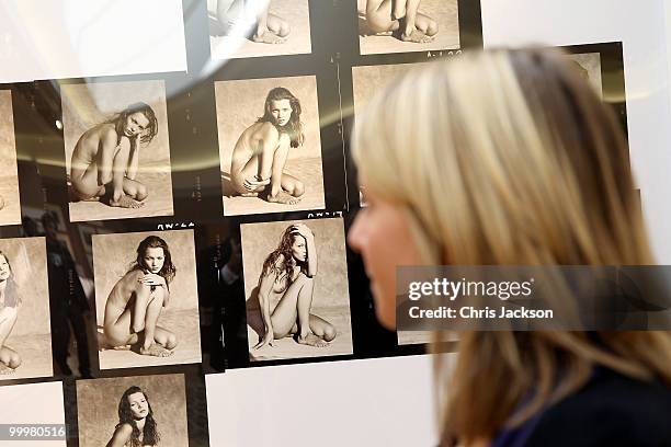 Christies employee looks at a contact sheet with 14 images of Kate Moss at Christie's South Kensington on May 19, 2010 in London, England. The...