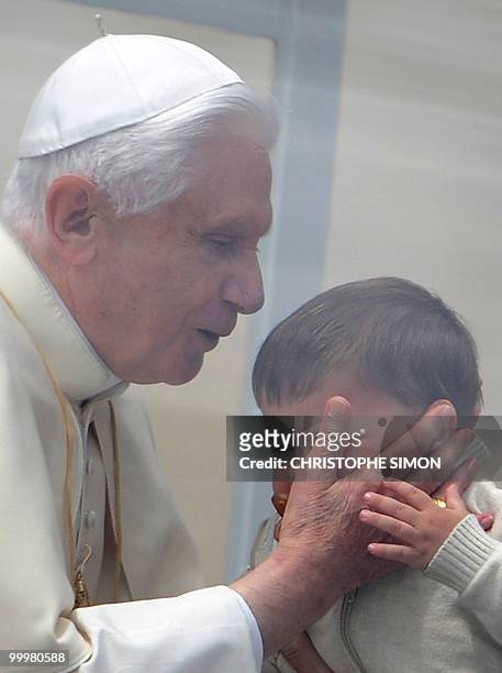 Pope Benedict XVI kisses the head of a child as he arrives for his weekly general audience at St Peter's square on May 19, 2010 at The Vatican. AFP...
