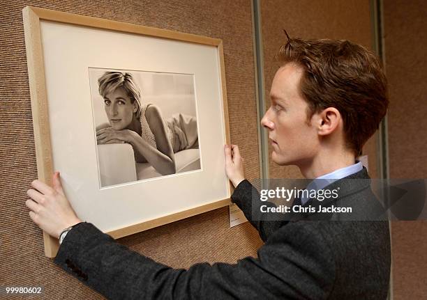 Christies employee holds up a photograph of Princess Diana by Mario Testino at Christie's South Kensington on May 19, 2010 in London, England. The...