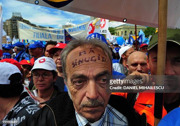 Romanian protester with writing on his forehead which reads in Romanian "I will kill myself" shouts anti-governmental slogans with others during a...