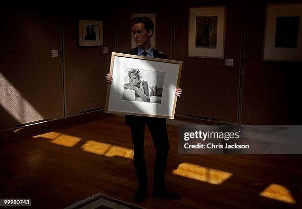 Christies employee holds up a photograph of Princess Diana by Mario Testino at Christie's South Kensington on May 19, 2010 in London, England. The...