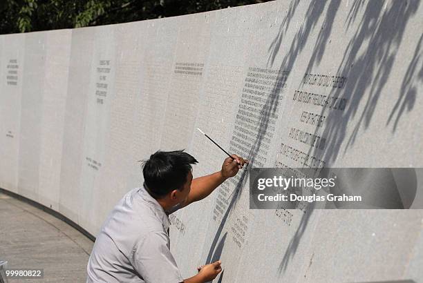 Binh Nguyen applys dye to the names on the National Japanese American Memorial to make them stand out. The National Japanese American Memorial to...