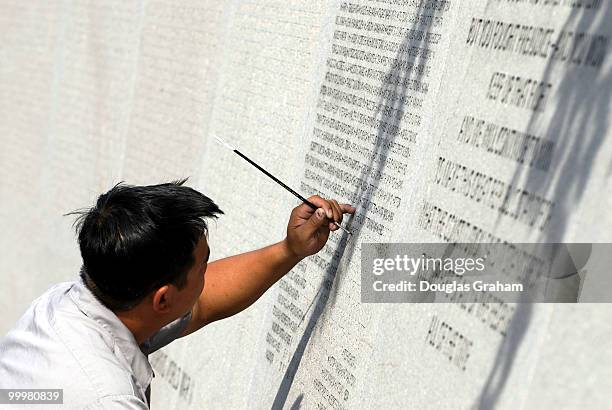 Binh Nguyen applys dye to the names on the National Japanese American Memorial to make them stand out. The National Japanese American Memorial to...