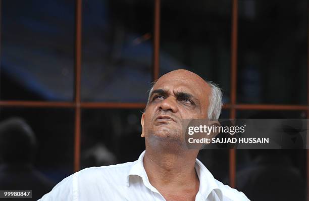 An Indian bystander watches share prices on a digital broadcast board outside The Bombay Stock Exchange in Mumbai on May 19, 2010. Indian shares fell...