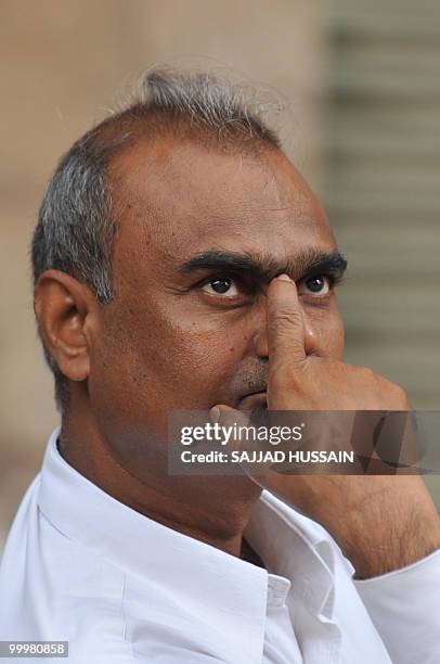 An Indian bystander watches share prices on a digital broadcast board outside The Bombay Stock Exchange in Mumbai on May 19, 2010. Indian shares fell...