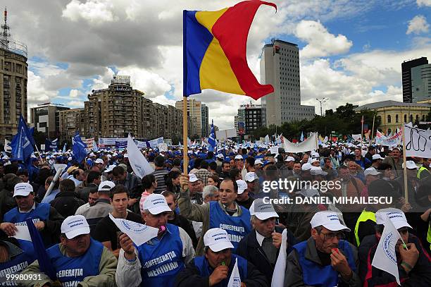 Romanian demonstrator waves a Romanian flag during a massive protest in the front of the Romanian Government headquarters in Bucharest May 19, 2010....