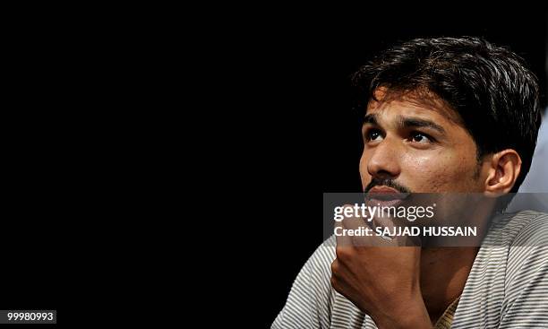 An Indian bystander watches share prices on a digital broadcast board outside The Bombay Stock Exchange in Mumbai on May 19, 2010. Indian shares fell...