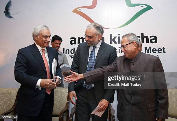 India Finance Minister Pranab Mukherjee shakes hands with Pakistan's High Commissioner to India Shahid Malik and CII President Hari S Bhartia looks...