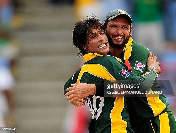 Pakistani bowler Mohammad Aamer celebrates with captain Shahid Afridi after taking the wicket of Australian batsman Cameron White during the ICC...