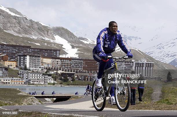 French football forward Djibril Cisse cycles during a training session around a lake, on May 19, 2010 in Tignes in the French Alps, as part of the...