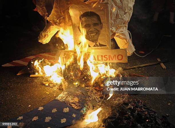 Leftist activists burn a portrait of US President Barack Obama in front of the US Embassy in Buenos Aires on August 12, 2009 during a protest against...