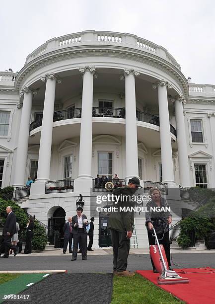 Woman vacuums the red carpet leading to the podium ahead of the official welcome ceremony for Mexico�s President Felipe Calderón and First Lady...