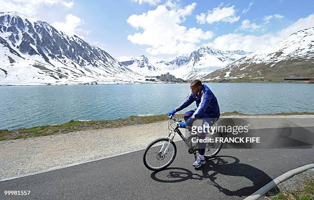 French football forward Thierry Henry cycles during a training session around a lake, on May 19, 2010 in Tignes in the French Alps, as part of the...