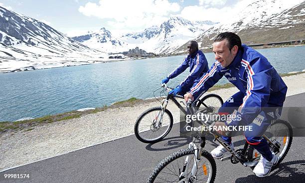 French midfielder Lassana Diarra and French forward Mathieu Valbuena cycle during a training session around a lake, on May 19, 2010 in Tignes in the...