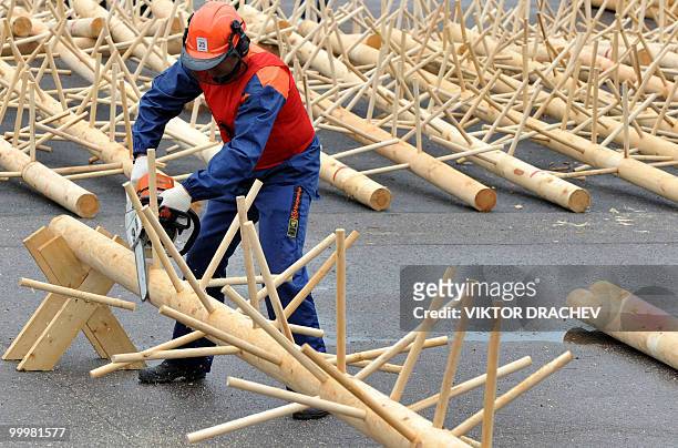 Belarussian lumberjack chainsaws a log during the "Forest 2010" lumberjack competition in Minsk on May 19, 2010. A few dozen men proved their...
