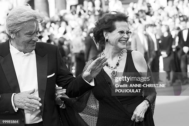 French actor Alain Delon arrives with Italian actress Claudia Cardinale for the screening of "Il Gattopardpo" presented during a special screening at...
