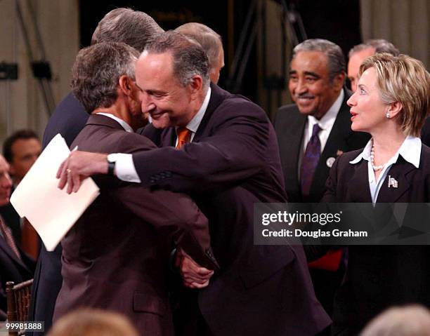 Sen. Charles Schumer, D-N.Y., center, hugs Senate Majority Leader Tom Daschle, D-S.D., while Sen. Hillary Clinton, D-N.Y., looks on during the...