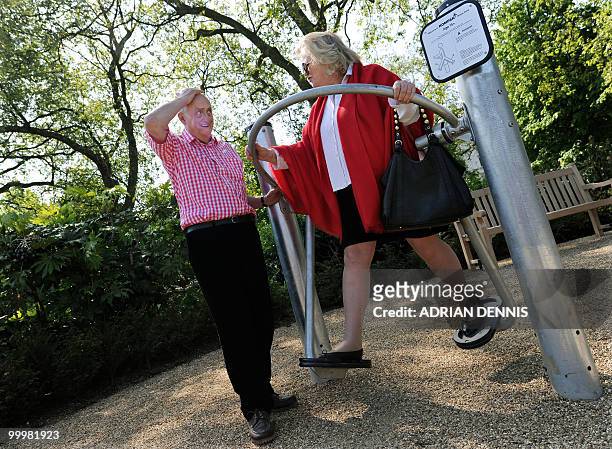 British pensioner Winston Fletcher talks with pensioner Margaret Mann as she use an exercise machine during the official opening of the first...
