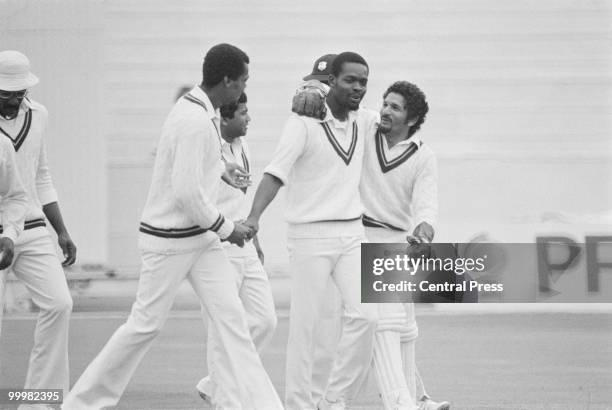 West-Indian wicketkeeper Deryck Murray congratulates bowler Michael Holding after he took the wicket of Indian opener Aunshuman Gaekwad at the...