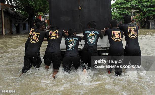 Group of Sri Lankan special force commandos push a stalled truck through floodwaters in Seeduwa a suburb of Colombo on May 19, 2010. The military has...