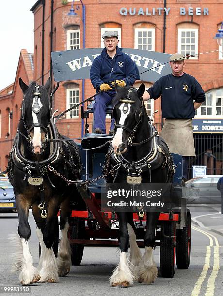 Head horseman Barry Petherick and horseman Martin Whittle pass in front of the Wadworths Brewery building as they deliver beer to local pubs using...