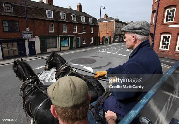 Head horseman Barry Petherick and horseman Martin Whittle pass in front of the Wadworths Brewery building as they deliver beer to local pubs using...