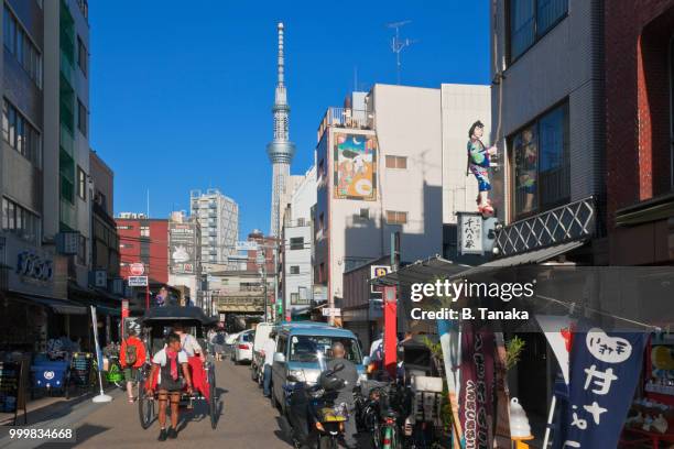 rickshaw and tokyo skytree in the old downtown asakusa district of tokyo, japan - tanaka stockfoto's en -beelden