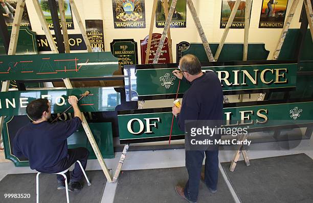 Traditional sign writer Paul Martin and Wayne Richings work on hand painting pub signs at the Wadworths Brewery on May 19, 2010 in Devizes, England....