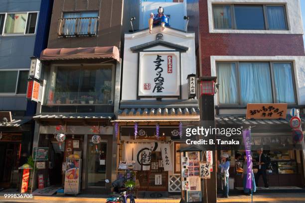 edo period figure on roof of ramen noodle shop in the old downtown asakusa district of tokyo, japan - distriktet taito bildbanksfoton och bilder