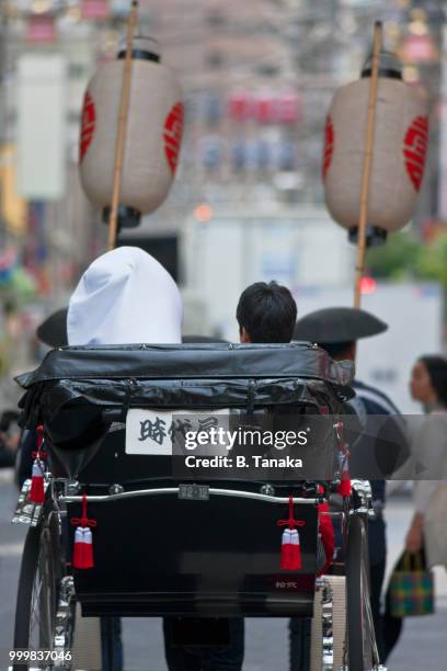 newlywed couple enjoy a rickshaw ride in the old downtown asakusa district of tokyo, japan - shitamachi stockfoto's en -beelden