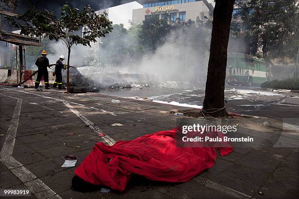 The body of a redshirt protester as firefighters put out a fire during the early morning attack on the red shirt camp May 19, 2010 in Bangkok,...