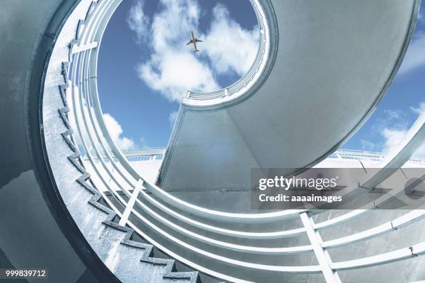 low angle view of flying airplane through spiral staircase - low flying aircraft bildbanksfoton och bilder