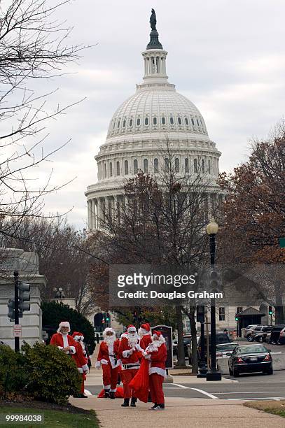 Large numbers of Santa's or Santa's helpers where out in force Wednesday morning handing out lumps of coal to Hill staffers on their way to work near...