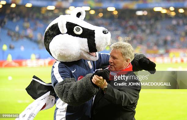 Fulham FC mascott dances with an official ahead of the final football match of the UEFA Europa League Fulham FC vs Aletico Madrid in Hamburg,...